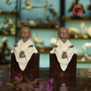 hình ảnh một chú tiểu nhắm mắt an yên ngồi thiền, bộ tượng còn mang những triết lý Phật giáo