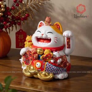Hình ảnh chú mèo với gương mặt tươi vui, một tay giơ cao như đang vẫy gọi khách hàng, đi cùng những chi tiết như thỏi vàng, cá chép, chuông vàng, bảng chiêu tài… tạo nên cảm giác sung túc và cát lành