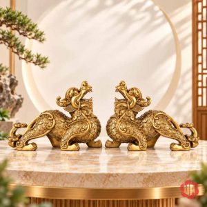 Hai tượng tỳ hưu vàng đồng đặt đối xứng trên mặt bàn sáng không có chữ quảng cáo