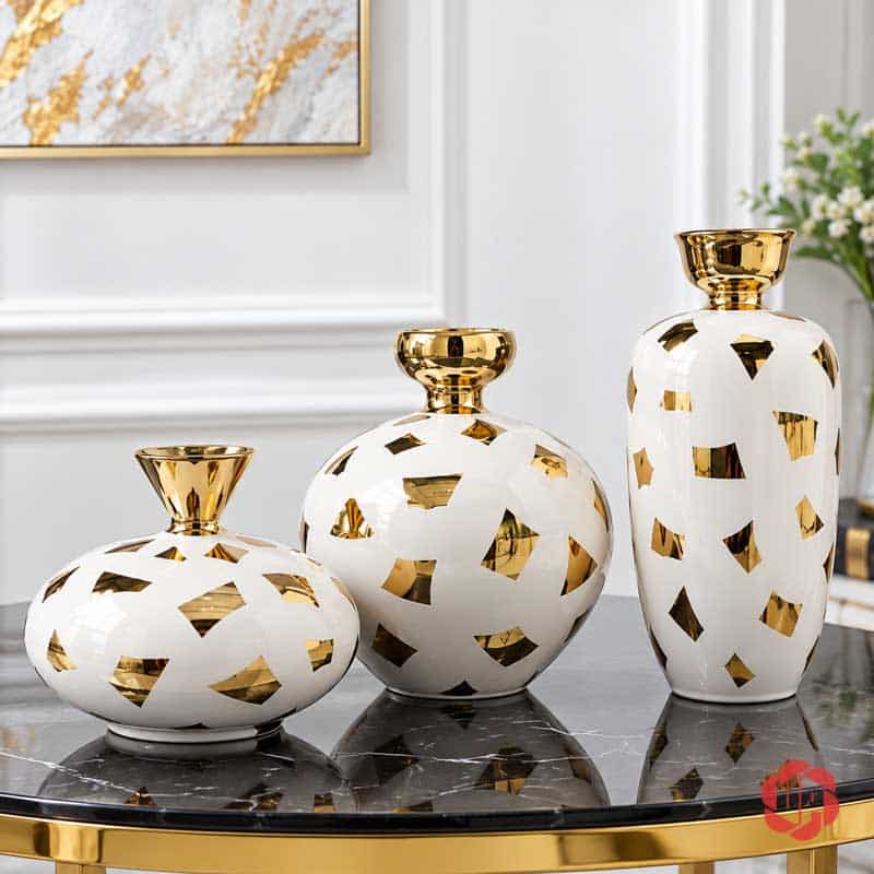 Bộ Bình Hoa Gốm Sứ Trang Trí Bắc Âu Họa Tiết Ánh Kim Cao Cấp UP053 Ba kiểu dáng bình hoa gốm sứ trắng vàng gồm bình cao, bình tròn và bình thấp trên bàn đá đen