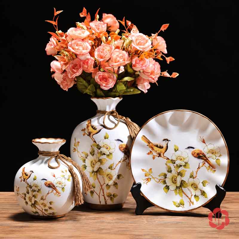 Bộ Bình Gốm Sứ Chim Và Hoa Trang Trí Phòng Khách 3 Món Bình gốm sứ họa tiết chim và hoa cắm bó hoa hồng đào, trưng bày cùng bình thấp và đĩa trang trí.
