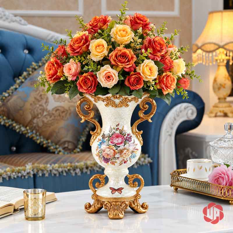 Bình Hoa Trang Trí Tân Cổ Điển Hai Quai Họa Tiết Hoa Hồng BG048 Bình hoa BG048 trắng kem dáng bầu hai quai cắm bó hoa hồng cam và vàng trước sofa xanh.