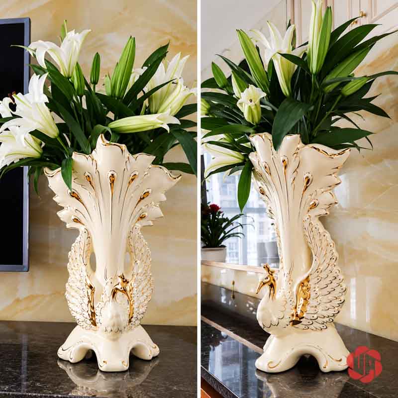 Bình Hoa Gốm Sứ Chim Công Trắng Viền Vàng Trang Trí Phòng Khách BG027 Bình hoa gốm sứ chim công trắng viền vàng cắm hoa ly trắng trong không gian nội thất sáng màu.