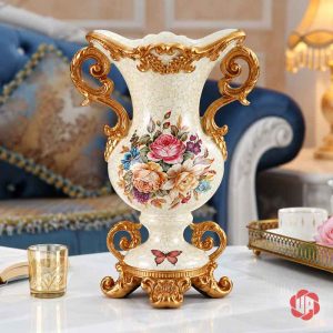Bình hoa BG048 dáng bầu màu trắng kem, hai quai vàng uốn xoắn và họa tiết hoa nhiều màu.