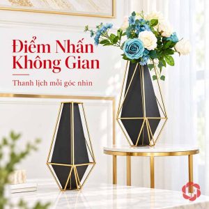 Bình hoa kim loại đen viền vàng trên bàn nhỏ cạnh sofa sáng màu