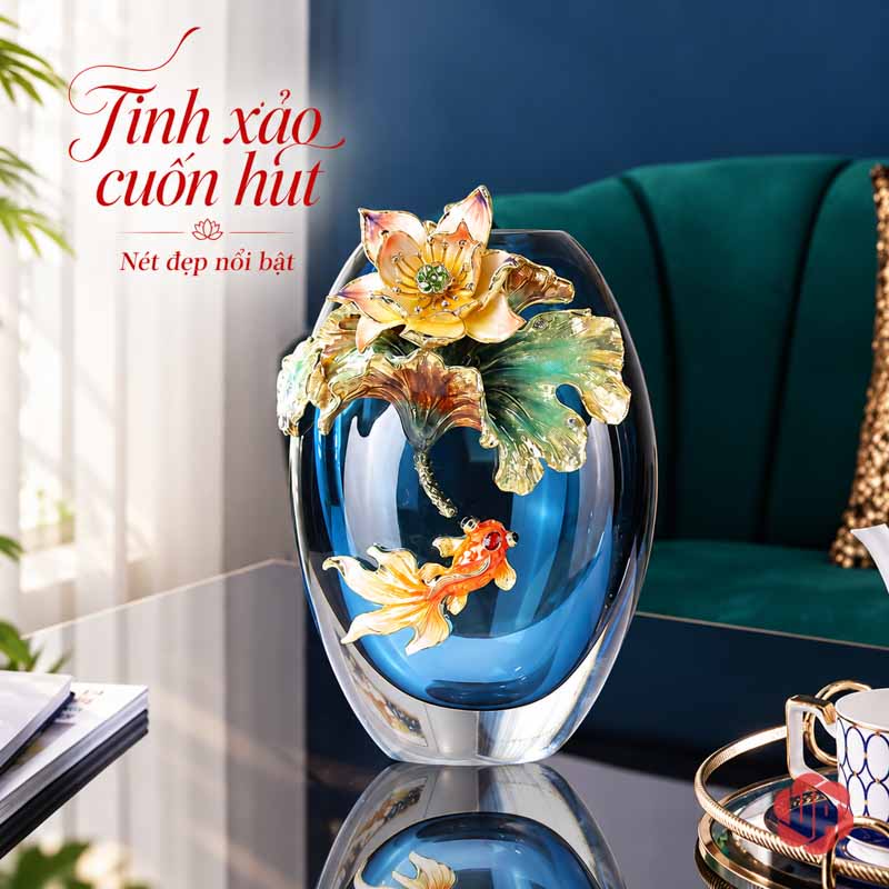 Bình Hoa Pha Lê Hoa Sen Và Cá Nghệ Thuật UPT19 Bình pha lê dáng thấp màu xanh lam với hoa sen nổi và một họa tiết cá màu cam, cạnh ghế xanh