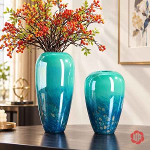 Bình cao xanh ngọc cắm cành quả đỏ cam cạnh bình thấp không hoa trên mặt bàn gỗ sẫm