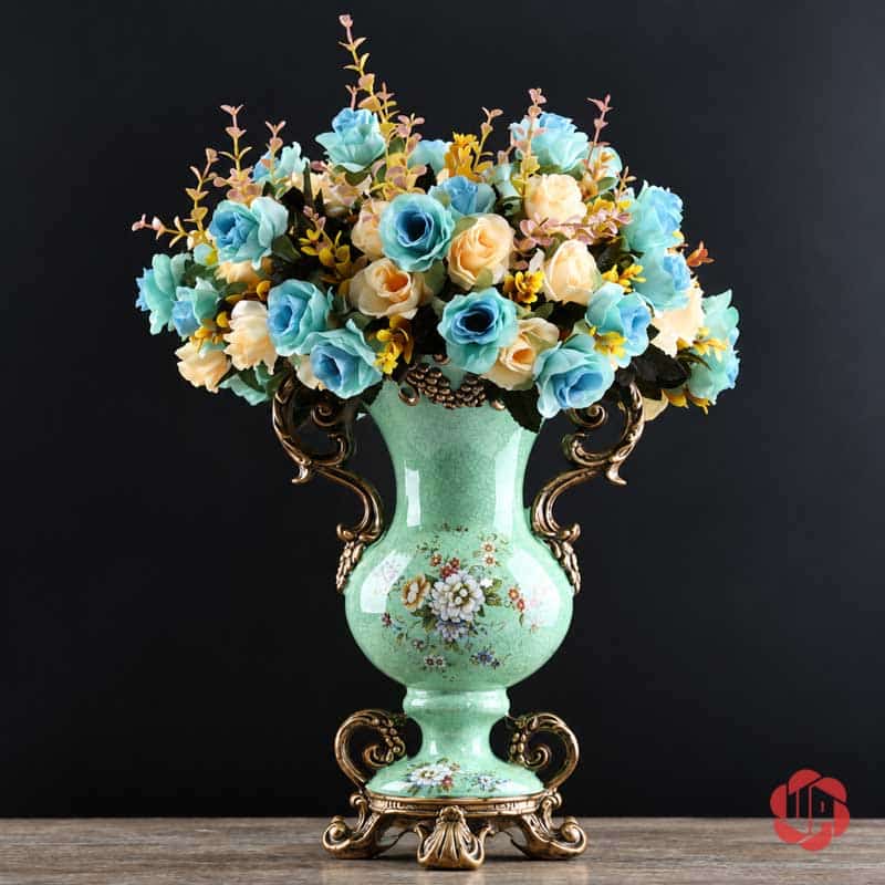 Bình Hoa Trang Trí Tân Cổ Điển Hai Quai Họa Tiết Hoa Hồng BG048 Bình hoa xanh ngọc BG048 cắm bó hoa hồng màu xanh lam và kem trên nền tối.