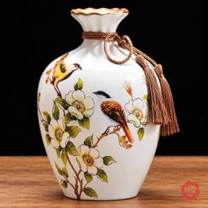 Bình gốm sứ cao 24 cm họa tiết chim và hoa với dây tua rua ánh vàng trang trí cổ bình.