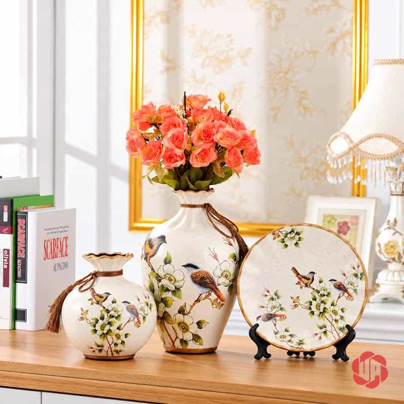 Bộ Bình Gốm Sứ Chim Và Hoa Trang Trí Phòng Khách 3 Món Bộ bình gốm sứ chim và hoa trưng bày trên bàn gỗ cùng bình hoa hồng màu cam.