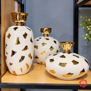 Bộ ba bình gốm sứ trắng vàng trưng bày trên kệ gỗ trang trí nội thất