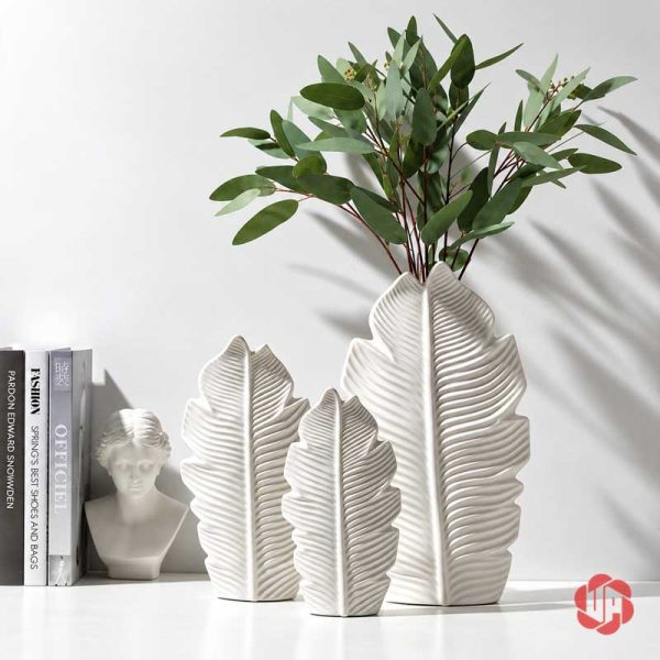 Ba bình lá gốm sứ trắng UP080 trưng bày cạnh sách và tượng trang trí