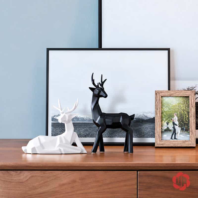 Bộ Tượng Hươu Decor Và Bình Hoa Sứ 3 Món Trang Trí Phòng Khách BG036 Cặp tượng hươu hình học màu đen và trắng trang trí trên bàn gỗ cạnh khung tranh và ảnh.