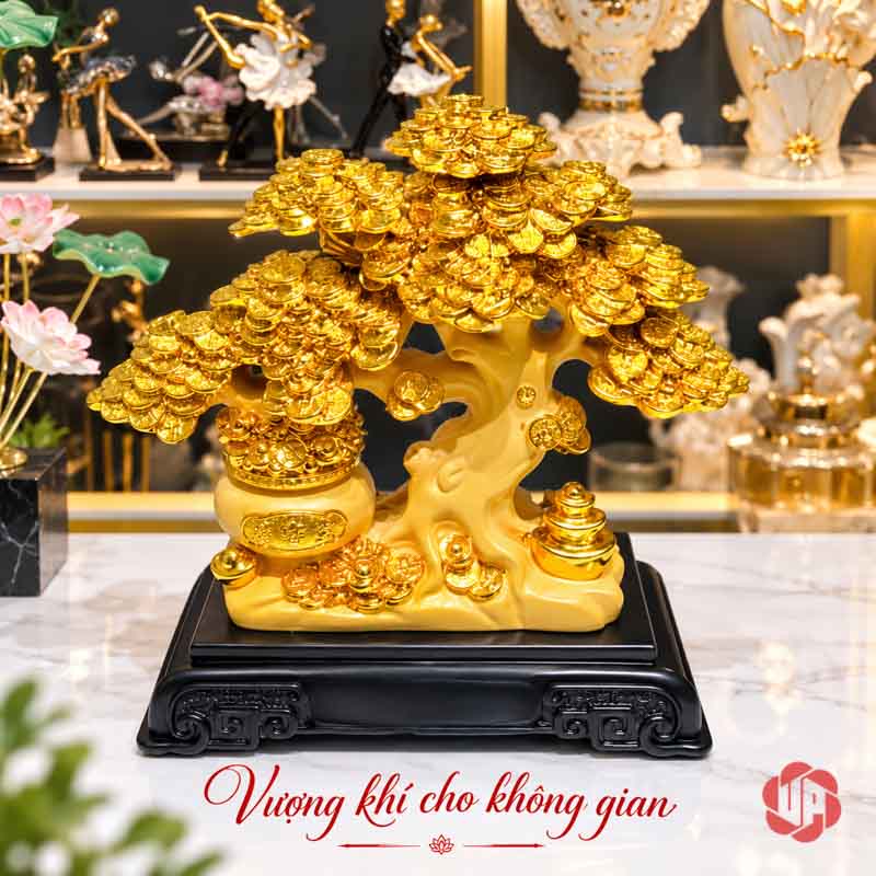 Vật Phẩm Phong Thủy Cây Tiền Vàng Tán Tầng UPV001-A Cây tiền vàng trên đế đen, phía sau là kệ đồ trang trí