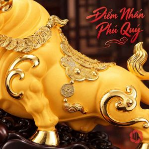 Chi tiết thân trâu vàng với họa tiết cuộn và trang sức