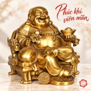 Gương mặt tươi cười của tượng Di Lặc ngồi ghế, tay nâng thỏi vàng