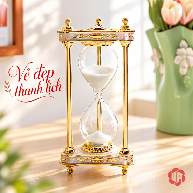 Đồ Trang Trí Bàn Làm Việc, Đồng Hồ Cát Cổ Điển UPV004 Đồng hồ cát khung vàng đặt trên mặt gỗ sáng cạnh bình hoa
