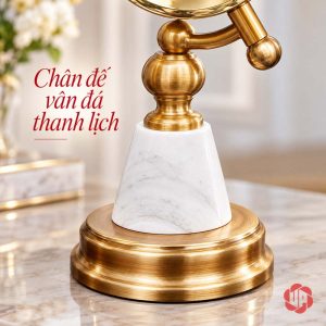 Cận chân đá trắng vân xám và đế tròn ánh vàng của đồng hồ