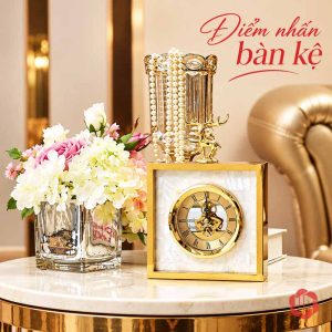 Đồng hồ hươu vuông bày cạnh bình hoa trên bàn tròn