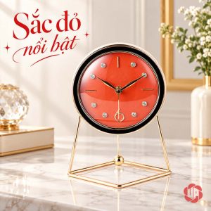 Đồng hồ mặt cam đỏ, vòng ngoài sẫm và chân khung ánh vàng