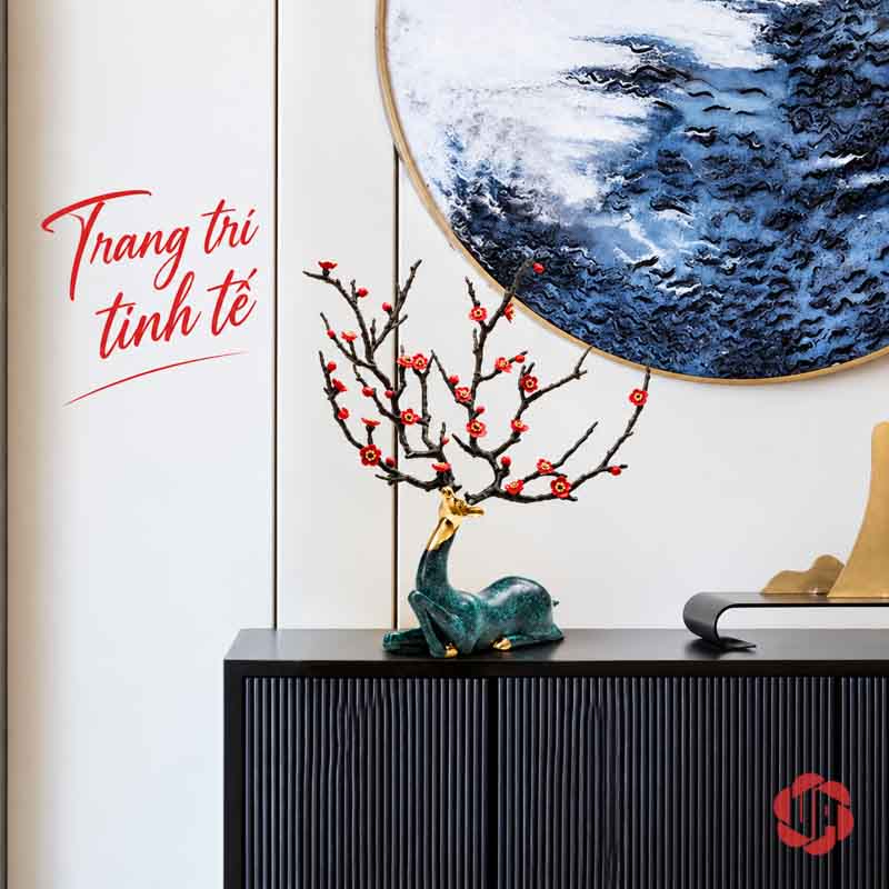 Tượng Hươu Bằng Đồng Tài Lộc, Dáng Nằm Hoa Đỏ UPD070 Tượng hươu nằm bày trên tủ đen dưới tranh tròn màu xanh