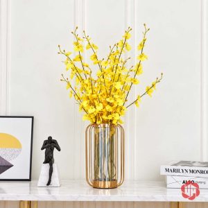 Lọ thủy tinh trang trí khung vàng cắm cành hoa vàng đặt cạnh tượng nhỏ