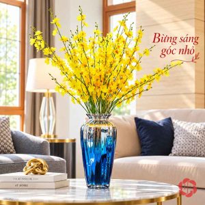 Lọ thủy tinh dáng cao màu xanh cắm cành hoa vàng bên ghế sofa