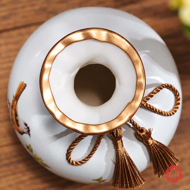 Bộ Bình Gốm Sứ Chim Và Hoa Trang Trí Phòng Khách 3 Món Cận cảnh miệng bình gốm sứ trắng với viền ánh vàng và dây tua rua màu đồng trang trí.