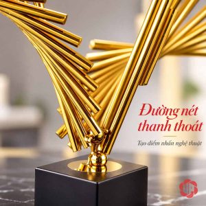 Tượng decor Đôi Cánh cận cảnh các thanh vàng giao nhau phía trên đế