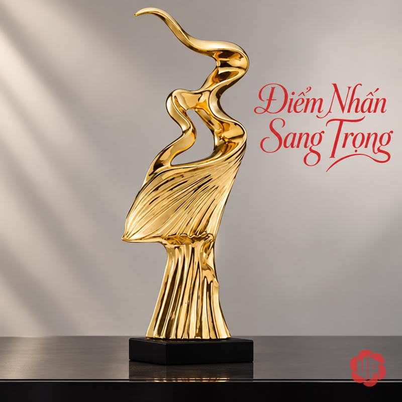 Tượng Decor Nghệ Thuật Tinh Thần Phấn Chấn UP056 Tượng decor mạ vàng trên mặt bàn tối trước tường xám