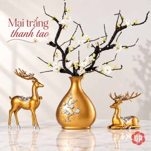 Cặp hươu vàng hai bên bình cắm cành hoa trắng