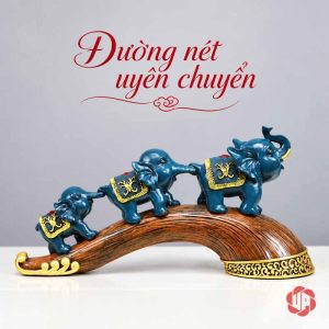 Tượng ba voi xanh nhìn nghiêng, đế nâu cong có viền hoa văn vàng ở đầu lớn