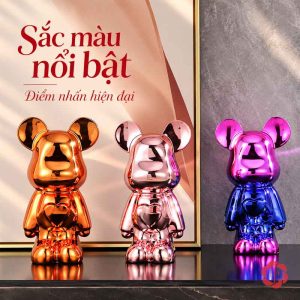 Ba tượng gấu bóng màu cam, hồng và chuyển sắc hồng xanh trên mặt kệ tối