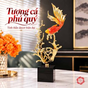 Một tượng cá đỏ đuôi vàng trên sóng rỗng và đế đen cạnh bình hoa cam