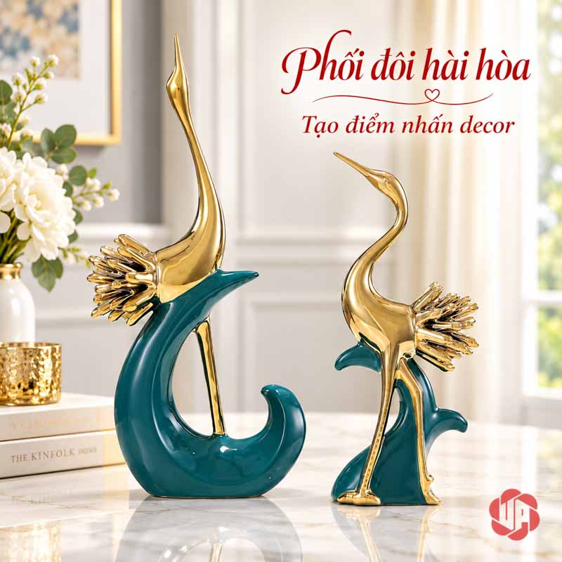 Đồ Decor Đẹp Cặp Chim Hồng Hạc Xanh Vàng UPV040 Hai tượng hồng hạc xanh vàng trên mặt bàn sáng, bên cạnh sách và hoa