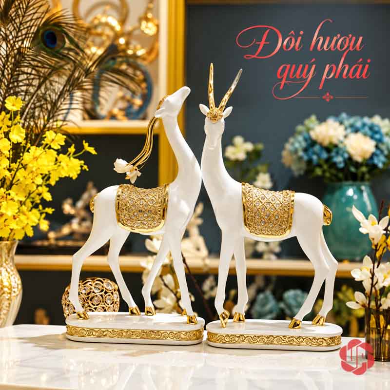 Đôi Tượng Dê Nghệ Thuật Trắng Vàng UPV064 Đôi dê trắng vàng đặt cùng hoa vàng trong không gian trang trí